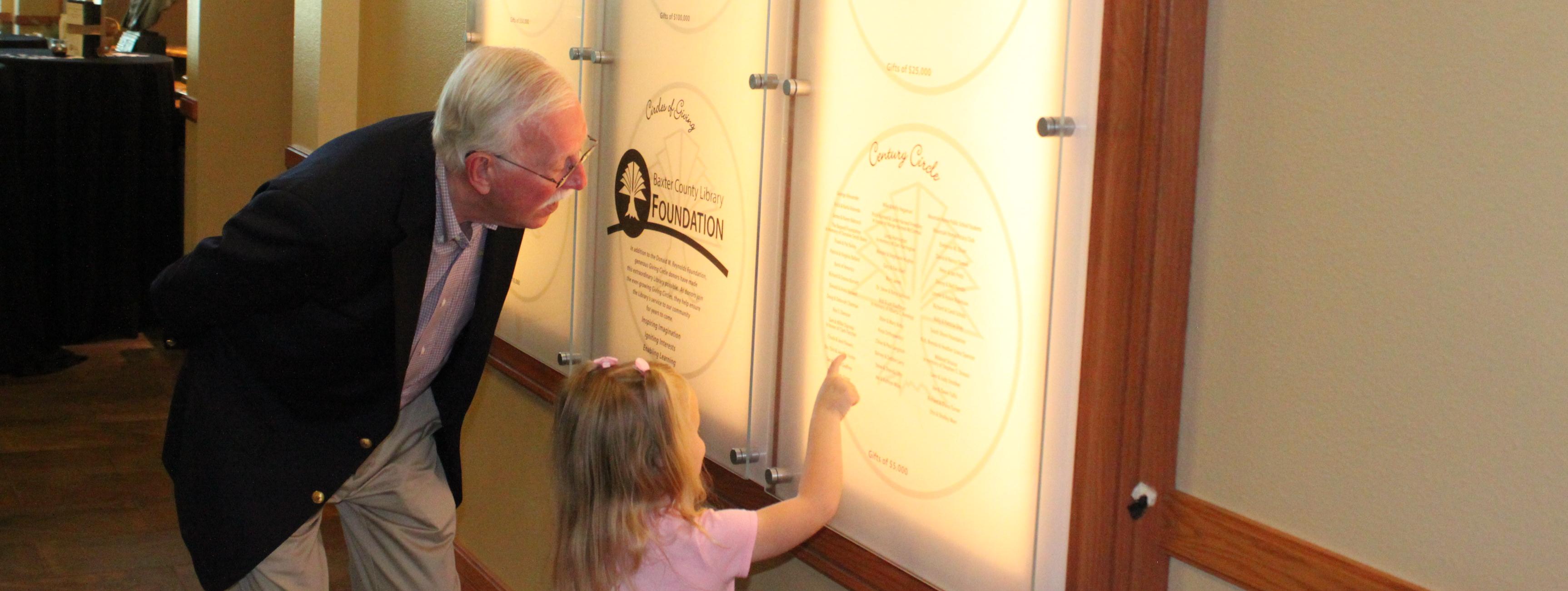 Older man and young girl at donor wall