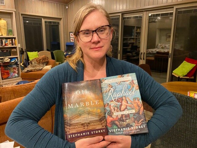 Author Stephanie Storey holding her two books
