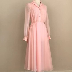 A light pink dress with long sleeves, a collared neck, and buttons down the front.