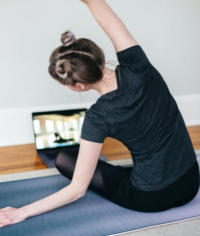 stock photo of girl doing yoga with a laptop