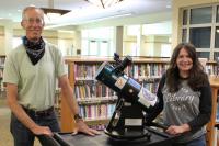 Library Staff Posing Near a Telescope