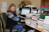Margie Kelley in the Friends of the Library workroom listing books for sale online.