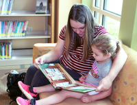 Mother and daughter reading a book together in the Kids Library at the Donald W. Reynolds Library Serving Baxter County.
