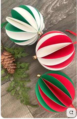 smal ornaments made of green and white, red and white, and green and red paper folded in a honeycomb style with a ribbon and gold clasp bead on each by a pine cone and some pine needles.