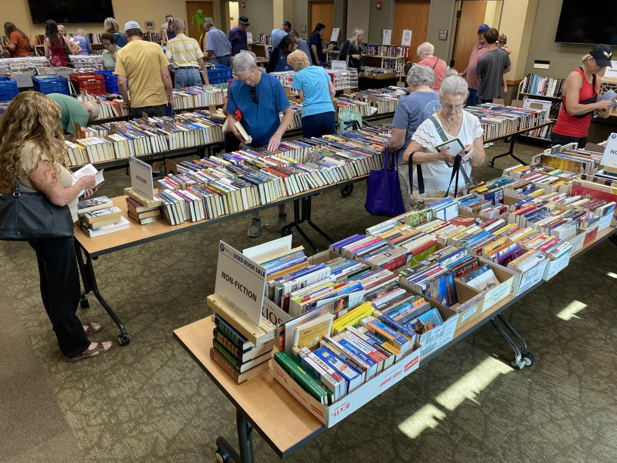 Library patrons browsing the large selection at one of the previous FOL booksales. 